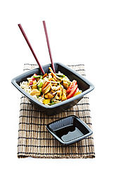 Chinesisches Essen in einer Schüssel mit Stäbchen und Sojasauce auf einer Strohmatte - MAEF005504