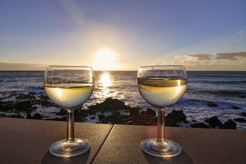 Spanien, La Gomera, Gläser mit Weißwein an der Wand im Valle Gran Rey, lizenzfreies Stockfoto