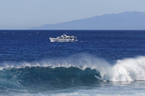 Spanien, Wellenbrecher mit Ausflugsboot auf La Gomera, lizenzfreies Stockfoto