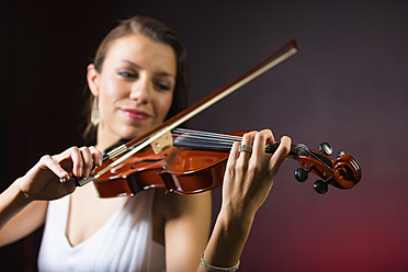 Young woman playing violin, smiling - ABAF000675