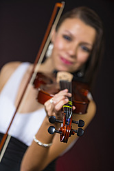 Young woman playing violin, smiling - ABAF000674