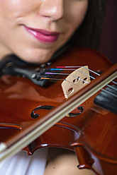 Junge Frau spielt Geige, lächelnd - ABAF000671