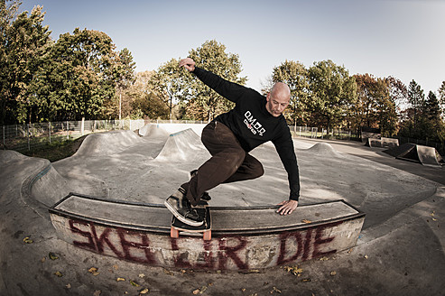 Deutschland, Nordrhein-Westfalen, Düsseldorf, Älterer Mann springt mit Skateboard - KJF000180