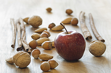 Apfel, Zimtstangen, Nüsse und Tannenzapfen für Weihnachten auf dem Tisch - ASF004731