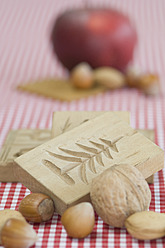 Apfel, Nüsse und Backformen für Weihnachten auf dem Tisch - ASF004739