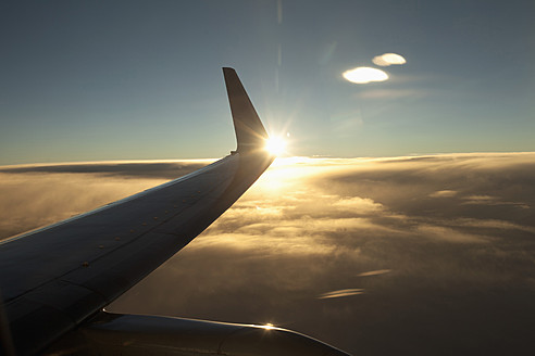 Flugzeugflügel über einer Wolke bei Sonnenuntergang - DBF000233