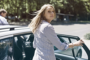 Germany, Duesseldorf, Young woman getting in to car - MF000445