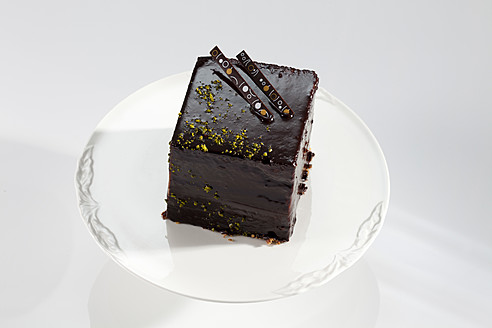 Teller mit dunklem Schokoladenkuchen auf weißem Hintergrund, Nahaufnahme - CSF016210