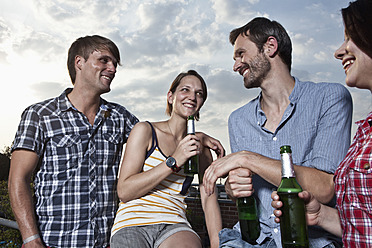 Deutschland, Berlin, Männer und Frauen haben Spaß auf der Dachterrasse, lächelnd - RBF001185