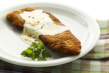 Plate of Schnitzel with cheese on napkin, close up - MAEF005599
