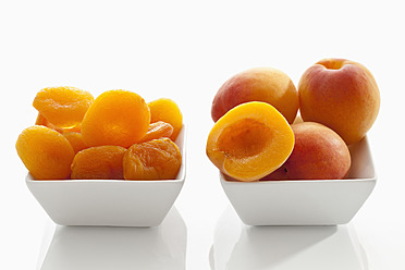Frische und getrocknete Aprikosen in einer Schale auf weißem Hintergrund, Nahaufnahme - CSF016276