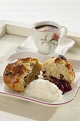 Cranberry scones with whipped cream and cup of coffee in tray, close up - CSF016341
