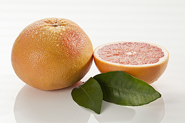 Grapefruit mit Blatt auf weißem Hintergrund, Nahaufnahme - CSF016377