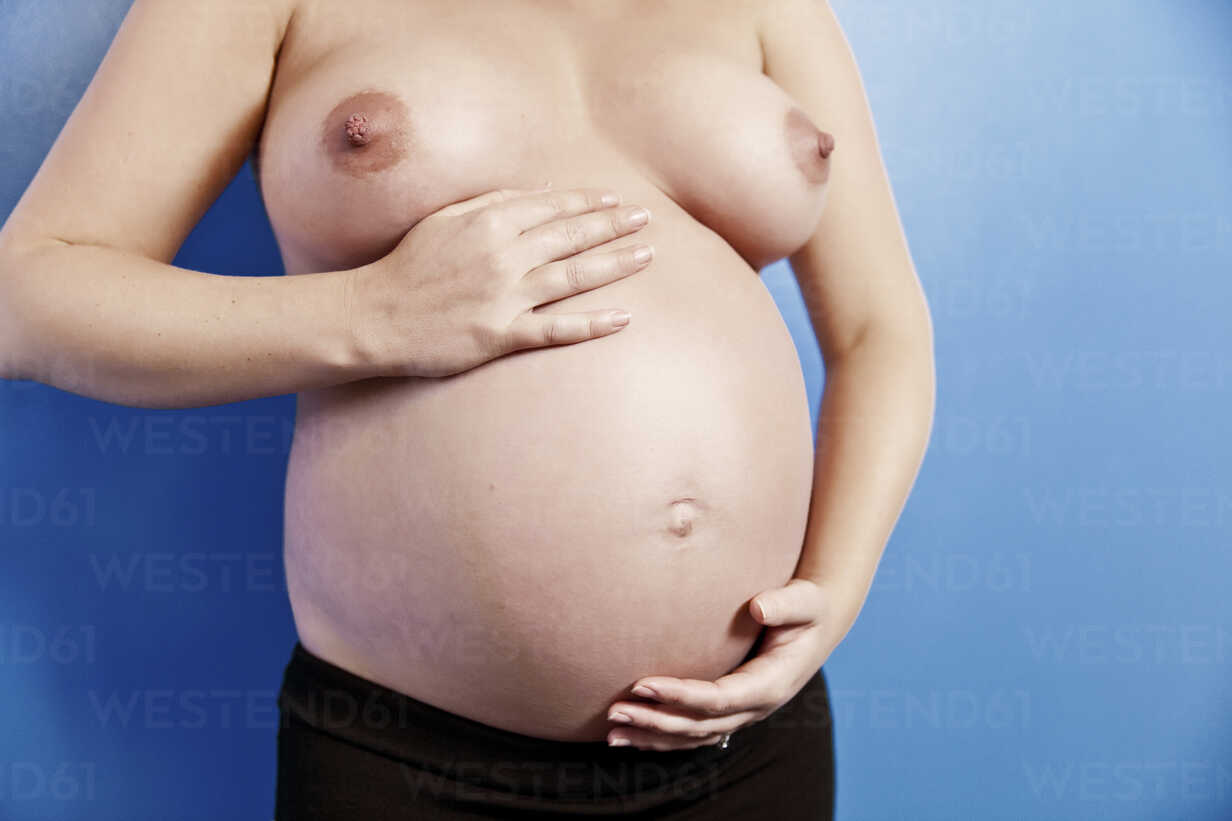 https://us.images.westend61.de/0000196630pw/pregnant-woman-showing-belly-and-breast-MFF000499.jpg