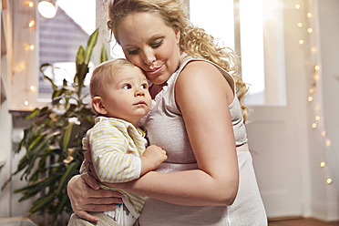 Deutschland, Bonn, Schwangere Mutter sitzt mit ihrem Sohn im Wohnzimmer - MFF000524