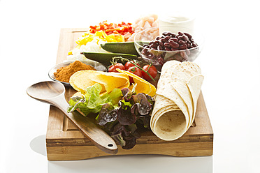 Various ingredients for fajitas and tacos on chopping board - MAEF005633