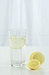 Glass of mineral water with lemon on table against white background, close up - ASF004775