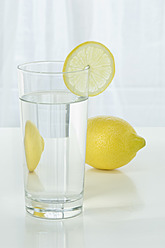 Glass of mineral water with lemon on table against white background, close up - ASF004776