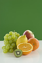 Verschiedene Früchte auf einem Tisch vor grünem Hintergrund, Nahaufnahme - ASF004784