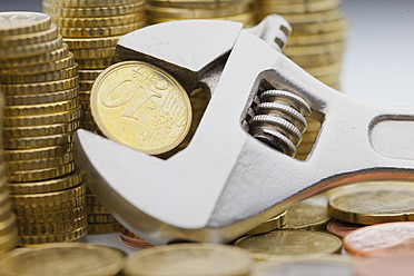 Stack of Euro coins and Ten cent coin held within adjustable wrench - FLF000188