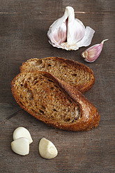 Geröstetes Brot mit Knoblauch auf Holztisch, Nahaufnahme - EVGF000047