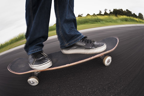 Deutschland, Nordrhein-Westfalen, Düsseldorf, Älterer Mann fährt mit Skateboard auf der Straße herum - KJF000184