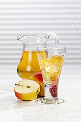 Glass of apple juice besides apples and pitcher - CSF016396