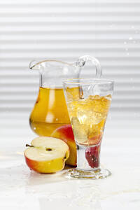 Glas Apfelsaft neben Äpfeln und Krug - CSF016396