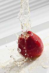 Apfelsaft mit kohlensäurehaltigem Wasser, das auf den Apfel gegossen wird - CSF016400