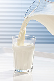 Milch wird in ein Glas gegossen, Nahaufnahme - CSF016416