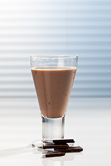 Glas Schokoladenmilch und Schokoladenstückchen, Nahaufnahme - CSF016428