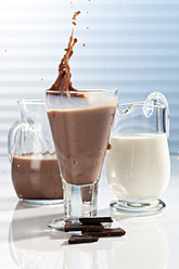 Glas und Karaffen mit Schokoladenmilch und Schokoladenstückchen, Nahaufnahme - CSF016431