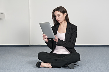 Deutschland, Berlin, Geschäftsfrau nutzt digitales Tablet im Büro - BFRF000157