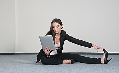 Germany, Berlin, Businesswoman exercising with digital tablet - BFRF000158