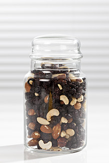 Variety of nuts and raisins in jar, close up - CSF016457