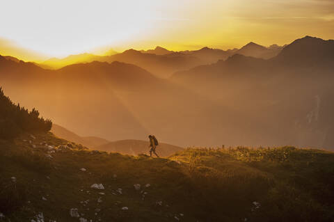 Austria, Salzburg Country, Man hiking through Niedere Tauern mountains at sunrise stock photo