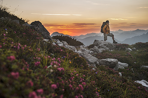 Österreich, Salzburger Land, Mann wandert bei Sonnenaufgang durch die Niederen Tauern - HHF004309