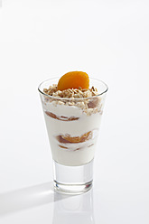 Glass of yogurt with muesli, fruit and cornflakes on white background, close up - CSF016581