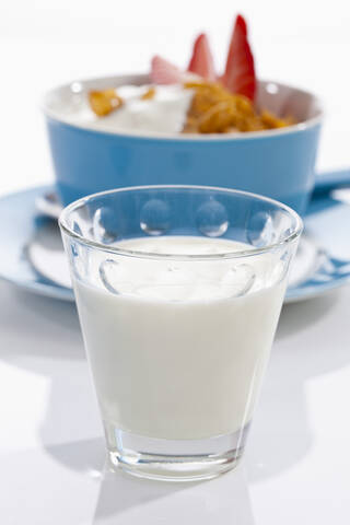 Glas Milch und Schale mit Kornblumen und Erdbeeren auf weißem Hintergrund, lizenzfreies Stockfoto