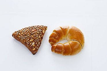 Croissant und Körnerbrot auf weißem Hintergrund, Nahaufnahme - CSF016611
