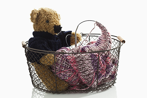 Korb mit Teddybär und Strickgarn auf weißem Hintergrund, Nahaufnahme - CSF016615