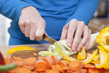 Deutschland, Bayern, München, Junge Frau schneidet Gemüse in der Küche, Nahaufnahme - RBF001100