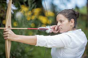 Austria, Salzburg Country, Young woman aiming arrow, close up - HHF004339