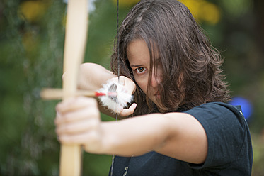 Austria, Salzburg Country, Young woman aiming arrow, close up - HHF004347