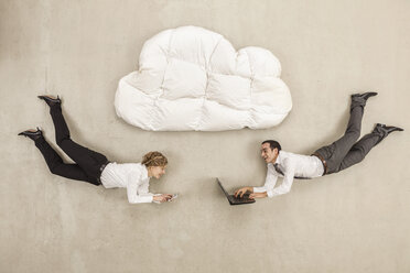 Business people with laptop and mobile phone below cloud shape pillow - BAEF000506