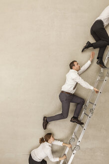 Business people climbing ladder in office - BAEF000525