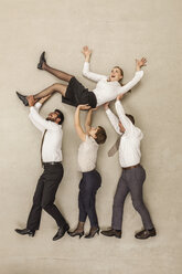 Business people carrying businesswoman in office - BAEF000545
