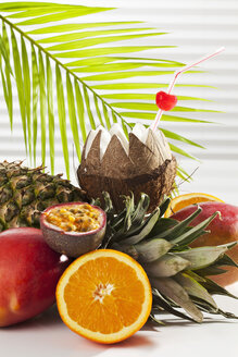 Coconut with drinking straw and fruits, close up - CSF016655