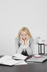 Frustrierte Geschäftsfrau am Schreibtisch - GWF002698