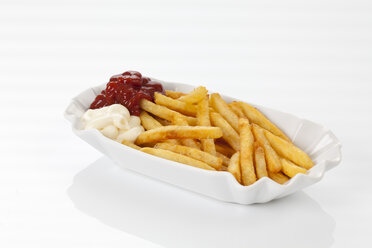 French fries with mayonnaise and tomato ketchup on plate, close up - CSF016676